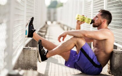 Resting athlete drinking water during running training