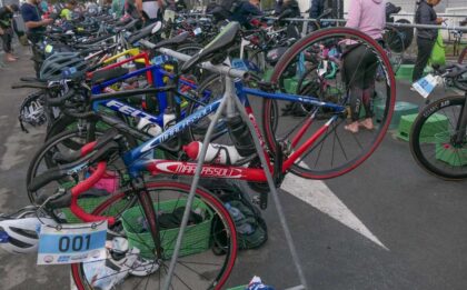 Bicycles racked in a well-organized triathlon transition zone, showcasing efficient setup for faster T1 and T2 transitions